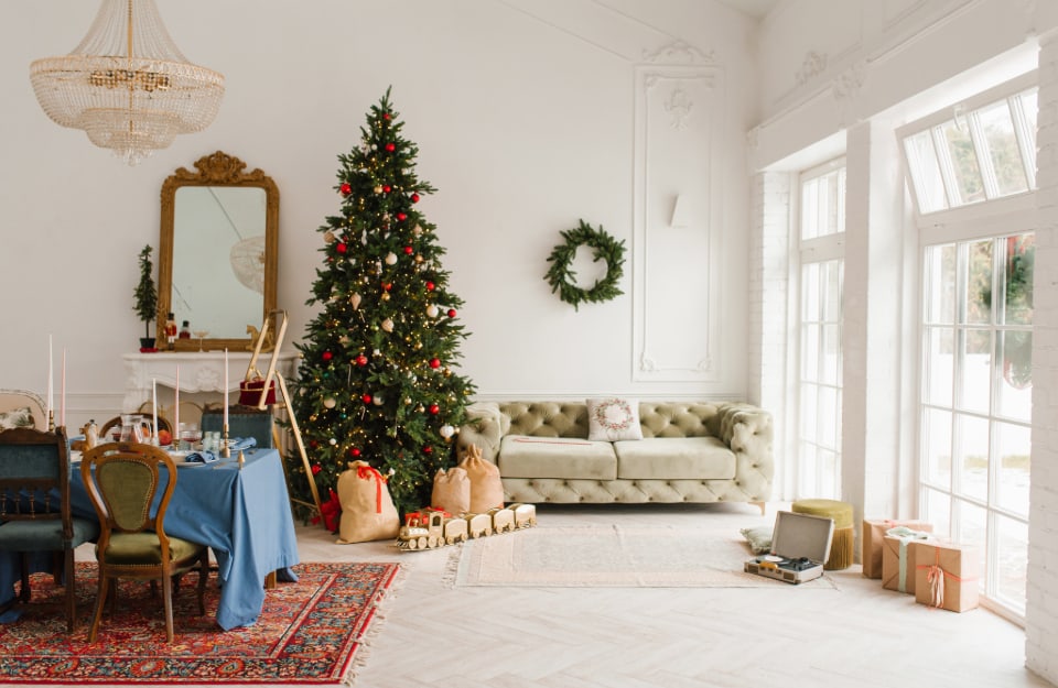 Un elegante e luminoso salotto in stile vintage, tutto suoi toni del bianco, decorato per il Natale con addobbi non eccessivi