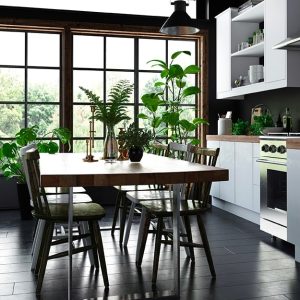 Cucina luminosa con grande vetrata a parete, mobili essenziali, grande tavolo e parquet scuro