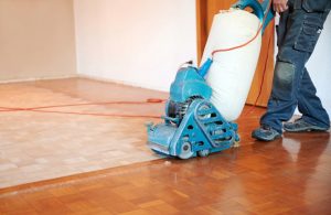 Un professionista sta usando una levigatrice su un parquet