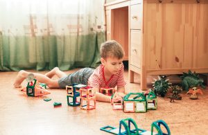 Bambino che gioca in una stanza con parquet in sughero