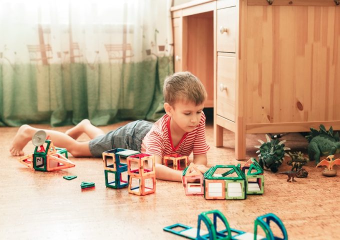 Bambino che gioca in una stanza con parquet in sughero