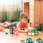 Bambino che gioca in una stanza con parquet in sughero