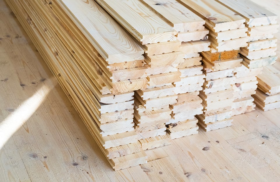 Una catasta di tavole di parquet in larice, su un pavimento a parquet pure in larice