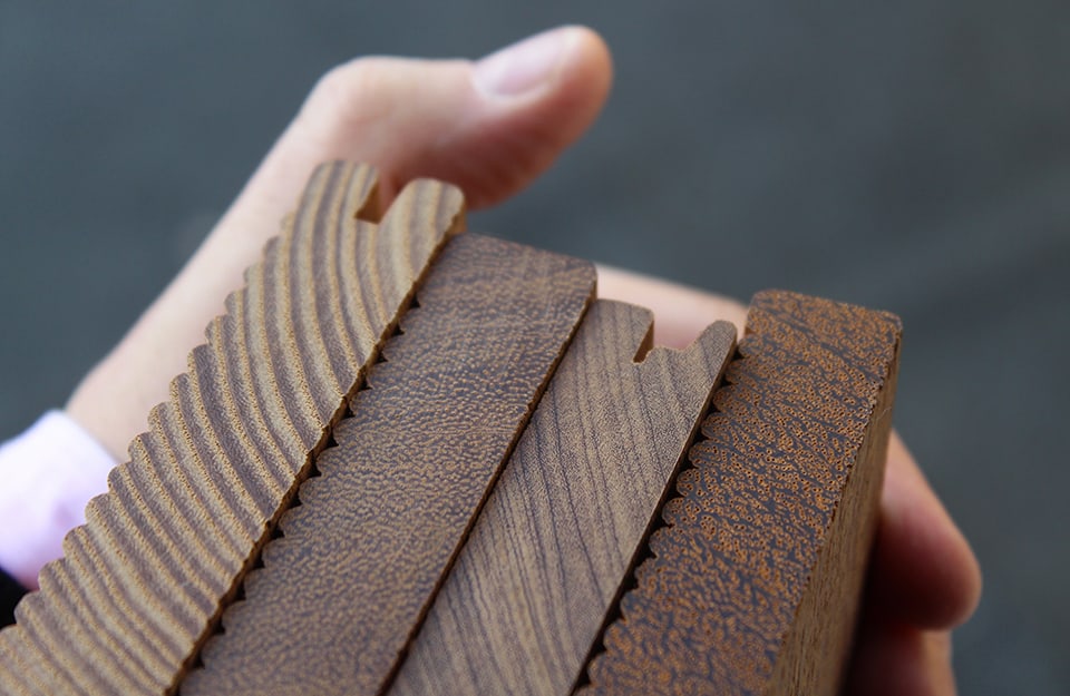 Primo piano su diverse tipologie di tavole di legno, strette da una mano