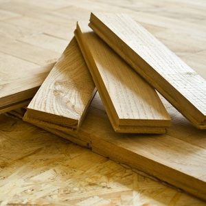 Tre tavole di parquet, posizionate a ventaglio sopra un parquet parzialmente posato
