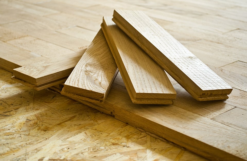 Tre tavole di parquet, posizionate a ventaglio sopra un parquet parzialmente posato