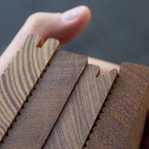 Primo piano su diverse tipologie di tavole di legno, strette da una mano