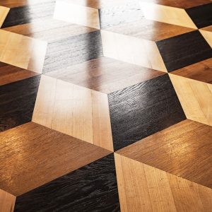 Parquet intarsiato a tre colori con elementi a rombo che formano ideali cubi tridimensionali
