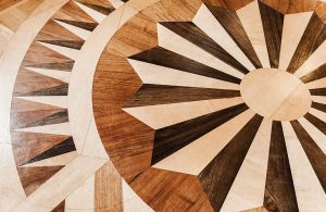 Particolare di un parquet intarsiato a diversi colori con motivo a rosone