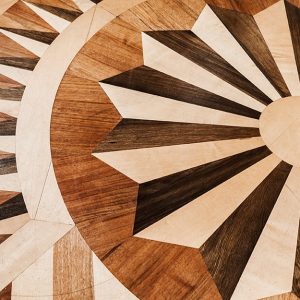 Particolare di un parquet intarsiato a diversi colori con motivo a rosone