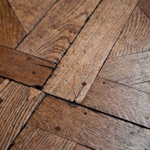 Dettaglio di un parquet rustico, con le sue imperfezioni e i segni del tempo