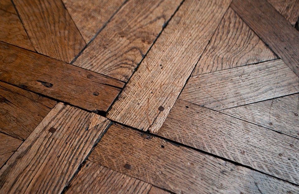 Dettaglio di un parquet rustico, con le sue imperfezioni e i segni del tempo