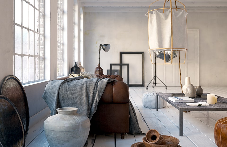 Grande salotto in ambiente open space dominato dal bianco. Il parquet è il legno antico recuperato e dipinto di bianco. C'è un sofà vintage in pelle e un tavolino da caffè in stile industrial