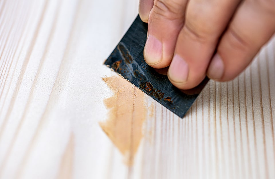 Riparazione di una fessurazione del legno con stucco e spatola