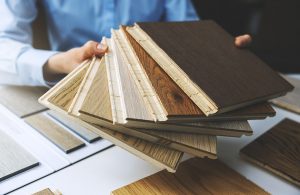 Un venditore mostra diversi campioni di parquet di diverse essenze, disposti a ventaglio
