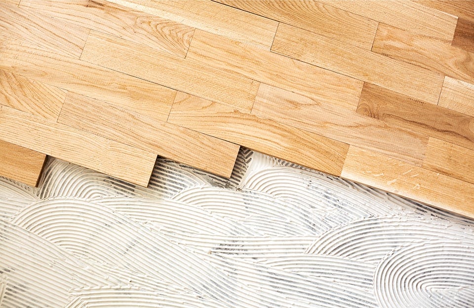 Un parquet parzialmente posato sopra a uno strato di colla