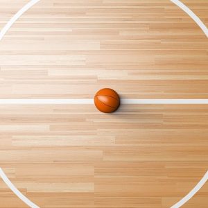 Centrocampo di un campo da basket visto dall'alto, con un pallone al centro esatto