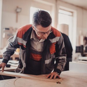 Un artigiano lavora una tavola di legno di frassino nel suo laboratorio