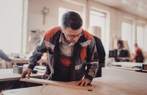 Un artigiano lavora una tavola di legno di frassino nel suo laboratorio