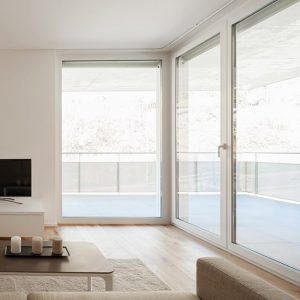 Salotto minimale e luminoso con grandi finestre che danno sull'esterno. Il parquet è in cabreuva incenso