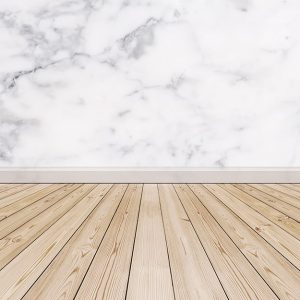 Un parquet in legno abbinato a una parete in marmo con battiscopa pure in marmo