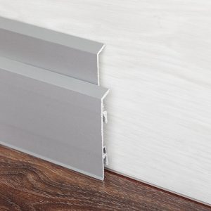Dettaglio di un battiscopa in alluminio su un parquet in legno scuro
