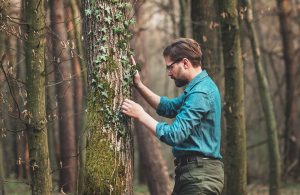 Un ricercatore studia il tronco di un albero in un fitto bosco