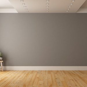 Stanza vuota con parquet in legno di pino, una sedia, parete color tortora e soffitto con faretti
