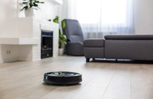 Salotto moderno con parquet con un robot aspirapolvere in azione
