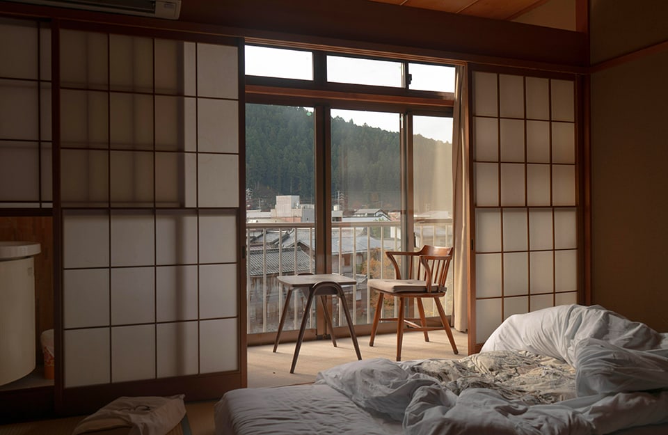 Camera da letto in stile giapponese, con pareti in carta di riso e futon sul pavimento