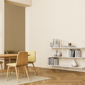 Sala da pranzo minimale con tavolo e sedie, mensole con libri e parquet in legno di pero
