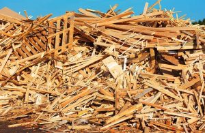 Una grande catasta di rifiuti legnosi, tra assi, pallet e frammenti vari