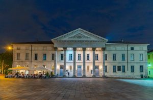 Vista notturna della facciata principale del Teatro Sociale di Como, illuminata