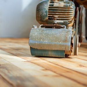 Una macchina levigatrice al lavoro su un vecchio parquet