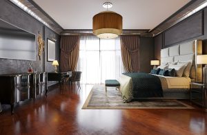 Lussuosa camera da letto in stile neobarocco con mobili laccati scuri, letto con testiera imbottita, grande lampadario e parquet in padouk