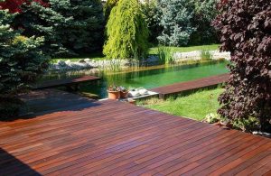 Decking in legno di cumaru su lago artificiale in un grande giardino