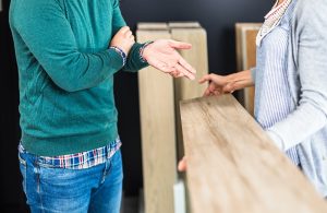 Due uomini di cui non si vede la testa stanno discutendo di un parquet in un negozio