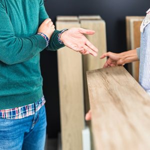 Due uomini di cui non si vede la testa stanno discutendo di un parquet in un negozio