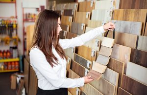 Una ragazza sta valutando diversi campioni di parquet in uno showroom