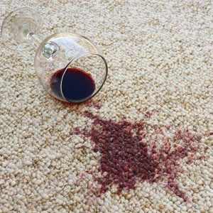 Un calice di vino rovesciato su una moquette bianca macchiata