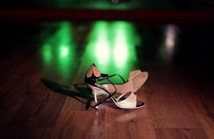 Un paio di scarpe da ballo femminili sul parquet di una pista da tango in legno di caldén