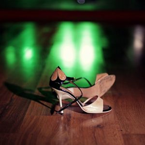 Un paio di scarpe da ballo femminili sul parquet di una pista da tango in legno di caldén