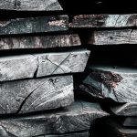 Delle assi di legno scuro fossilizzato accatastate le une sulle altre