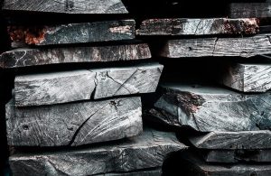 Delle assi di legno scuro fossilizzato accatastate le une sulle altre