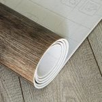 Un rotolo di linoleum effetto-parquet steso su un pavimento in lineolum dello stesso tipo