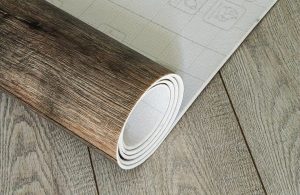 Un rotolo di linoleum effetto-parquet steso su un pavimento in lineolum dello stesso tipo