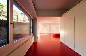 Un edificio pubblico con delle grandi vetrate e il pavimento in linoleum rosso