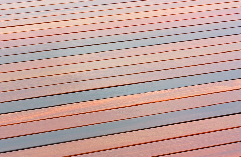Un decking in massaranduba con assi viste diagonalmente caratterizzate da colori che vanno dal rossastro al violaceo