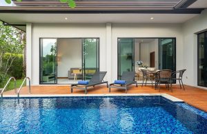 Esterno di una villa con piscina con decking in legno e grandi finestre