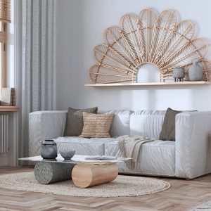 Salotto arredato in stile scandinavo-rustico, con sofa grigio e mobili in legno chiaro su parquet sbiancato e tappeto